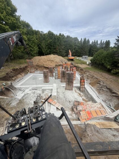 Coffrages de colonnes dressés sur une semelle coulée, vus depuis la cabine d'un camion-grue