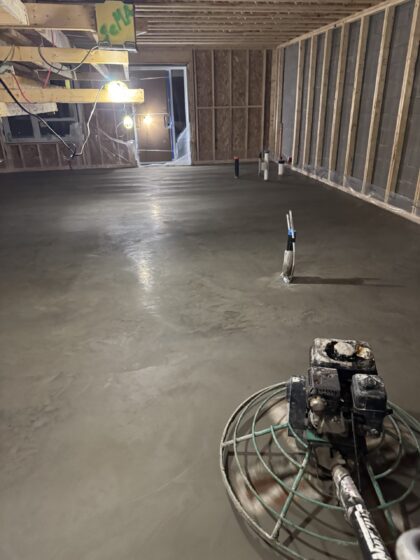 Dalle de béton intérieure lissée à la truelle mécanique dans un sous-sol en cours de construction