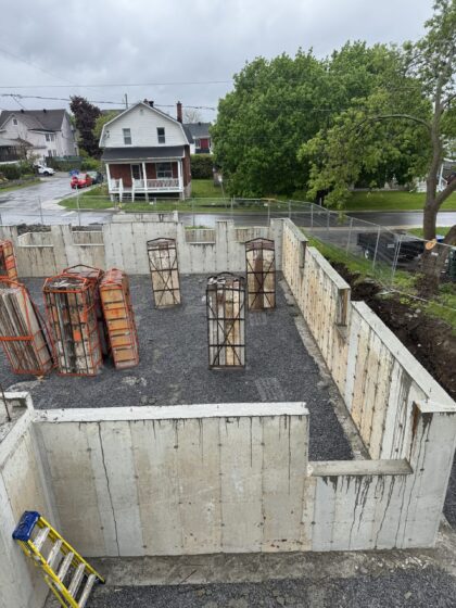 Murs de fondation en béton coulés et décoffrés autour d'un sous-sol rempli de pierre concassée
