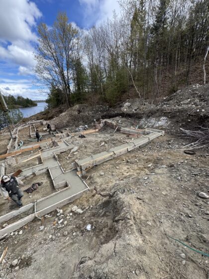 Semelles de fondation coulées et coffrées sur un terrain en pente en bordure d'un lac